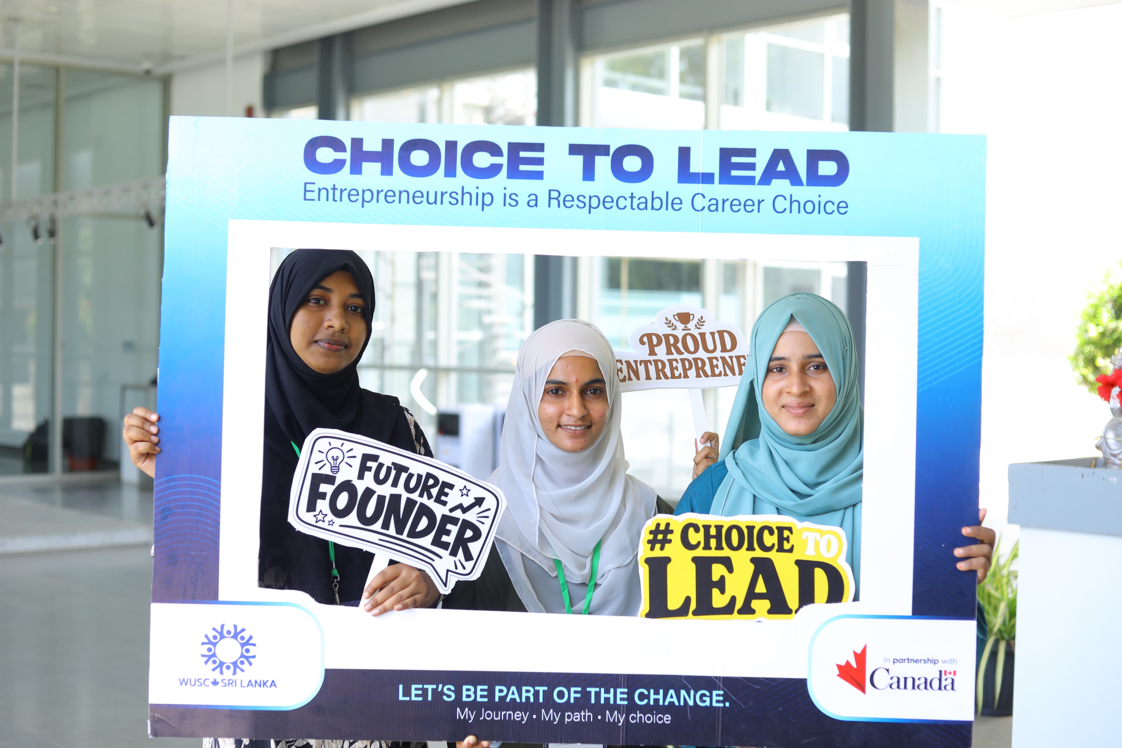Three women entrepreneurs holding the Choice to Lead frame